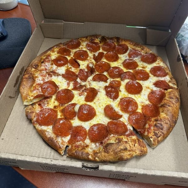 A whole pepperoni pizza from Gezziny's Homemade Pizza in a cardboard delivery box.