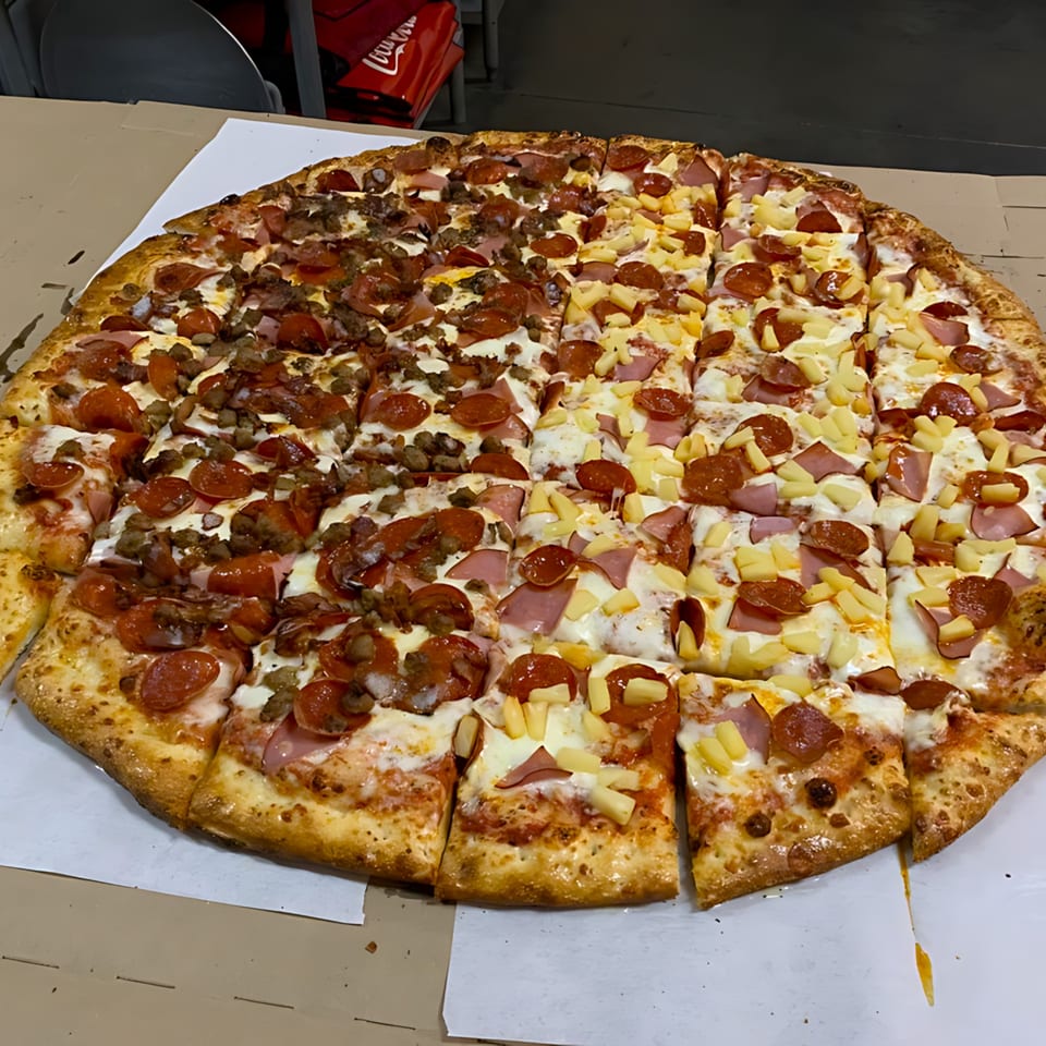 A large Gezziny's pizza, half with meat toppings and half with pineapple and ham.