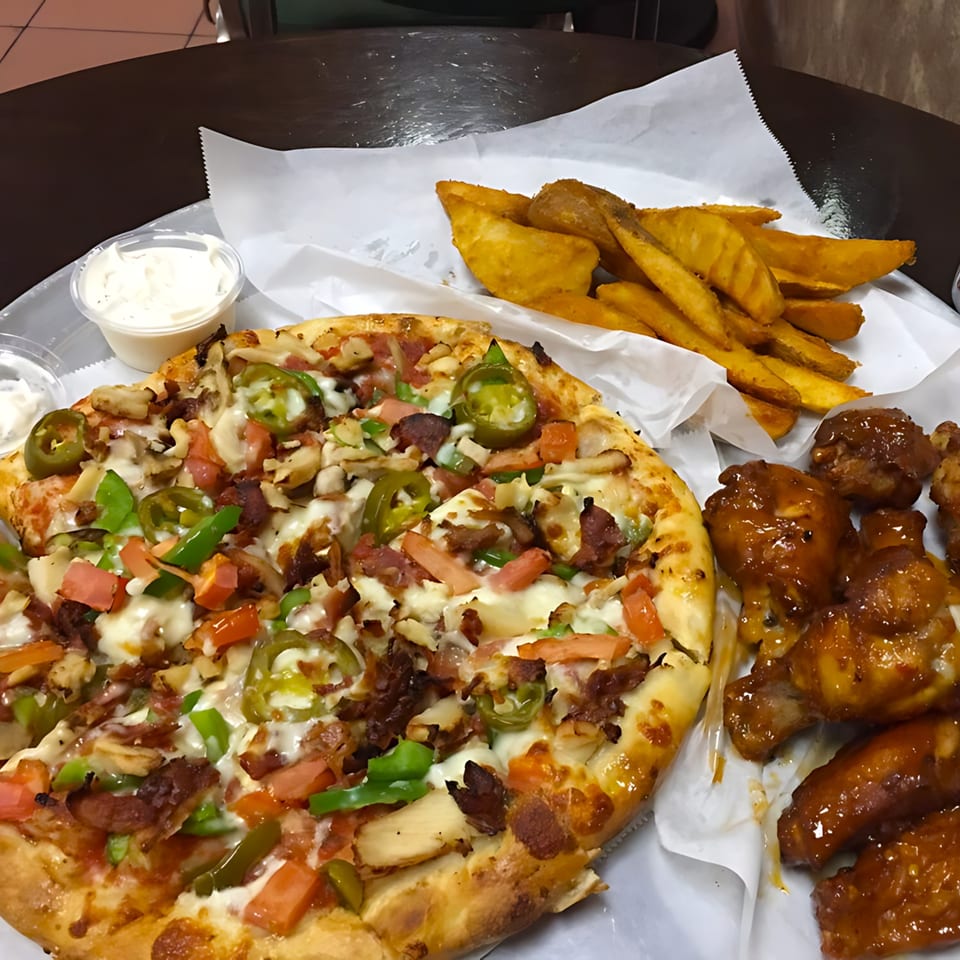 Gezziny's pizza with jalapenos, tomatoes, and bacon, served with potato wedges and BBQ wings.